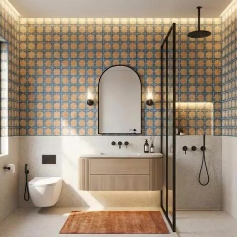 Modern bathroom walkthrough with blue and beige patterned wall tiles, terrazzo floor, and fluted wood vanity