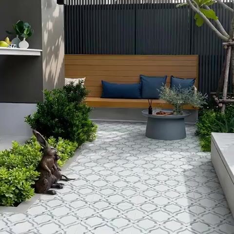Modern outdoor seating with patterned floor tiles and wooden bench
