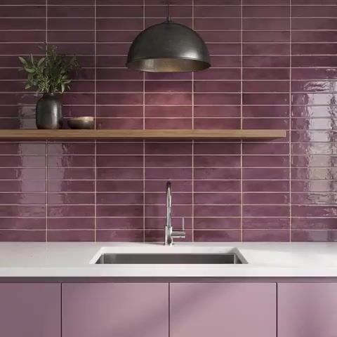 Modern kitchen walkthrough with glossy plum subway wall tiles, pastel mauve laminate cabinets, and white quartz countertop