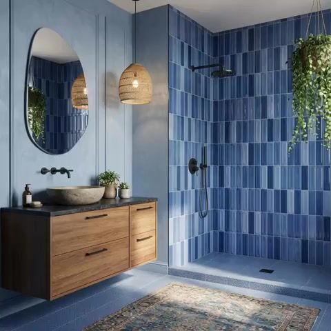 Modern bathroom walkthrough with blue subway wall tiles, wooden floating vanity, and matte blue floor tiles