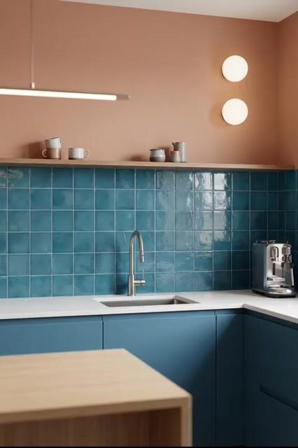 Scandinavian kitchen walkthrough with blue laminate cabinets, teal square backsplash tiles, and white quartz countertop