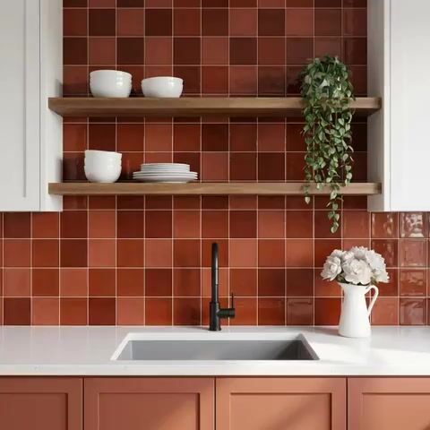 Modern kitchen walkthrough with terracotta square wall tiles, white quartz countertop, and matte peach laminate cabinets