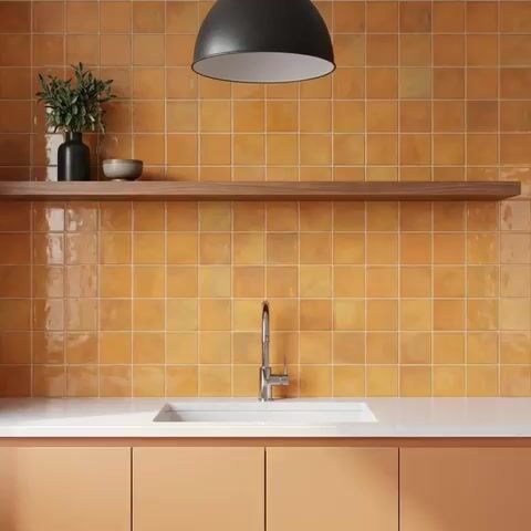 Modern kitchen walkthrough with terracotta square wall tiles, peach laminate cabinets, and white quartz countertop