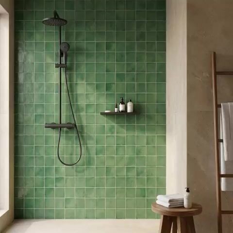 Minimalist bathroom walkthrough with green square wall tiles and beige stone-look floor tiles