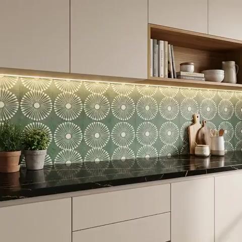 Modern kitchen walkthrough with geometric green patterned backsplash tile and black marble countertop