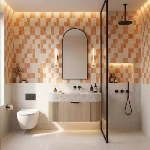 Modern bathroom walkthrough with terracotta and cream patterned wall tiles, terrazzo floor, and fluted wood vanity
