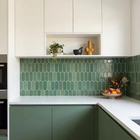 Modern kitchen walkthrough with sage green laminate cabinets, white laminate overheads, and scallop green backsplash tile