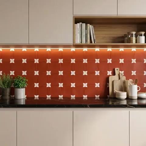 Modern kitchen walkthrough with terracotta geometric backsplash tile and black marble countertop