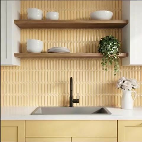 Modern kitchen walkthrough with yellow geometric backsplash tile, white quartz countertop, and light wood open shelves